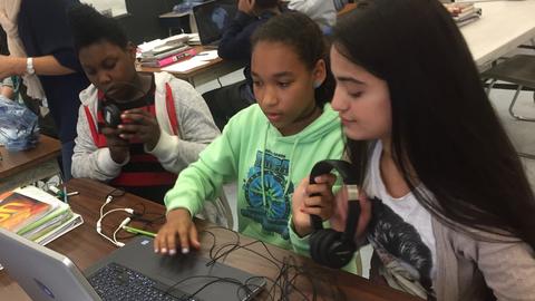 three students in a classroom